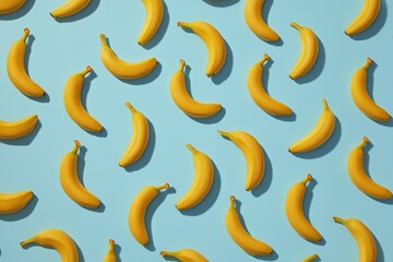 Seamless pattern of simple yellow banana icons arranged on light blue background, flat lay style minimal tropical fruit design, playful repeating decorative texture for fresh summer concepts