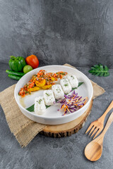 Balinese spicy fish served with rice and vegetables, topped with vibrant chili and spice salsa. This dish bursts with aromatic herbs and authentic island flavors.