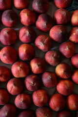 Beautiful tasty fresh peaches laying out on a table with bright red, orange and peach colors.