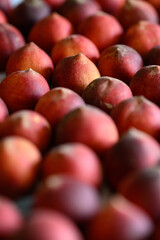 Beautiful tasty fresh peaches laying out on a table with bright red, orange and peach colors.
