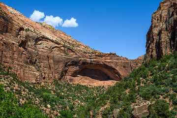 Ancient rock landscape created by erosion over time, valley cliff walls, green plants on valley...