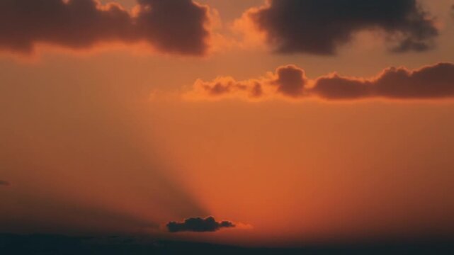 Beautiful sunset time lapse in orange sky with fluffy clouds. Warm romantic sky and clouds at sunrise. winter sky.