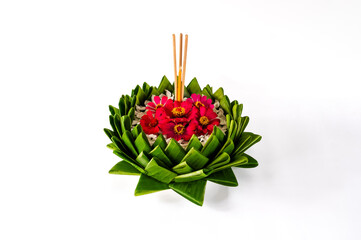 Banana leaf Krathong that have 3 incense sticks and candle decorates with pink flowers for Thailand full moon or Loy Krathong festival isolated on white paper background.