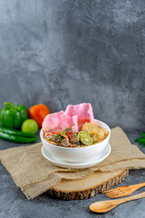 Soto Padang is a classic Minang beef soup with clear broth, fried crunchy beef, vermicelli, potato croquette, and pink sago crackers. Its rich spices and fresh toppings create a flavorful, vibrant bow