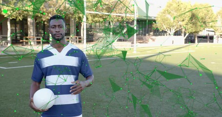 Male rugby player shifting ball grip as green mesh emerging and enveloping for tech demo - Powered by Adobe