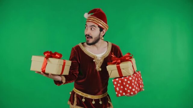 Man in elf costume holding christmas presents against a green screen background in a studio christmas elves green screen video