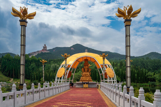 Genre sculpture at the foot of the Mount Lushan with the Nanshan Great Buddha Statue in the Nanshan Tourist scenic area on a summer day, Longkou, Yantai, Shandong, China