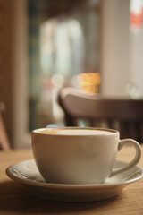 Warm coffee cup placed on a wooden table in a cozy cafe