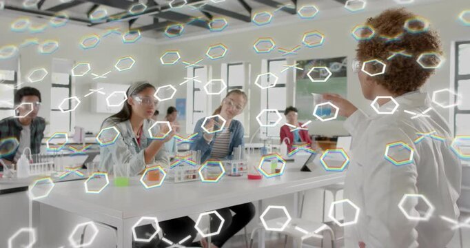Science instructor raising beaker showing reaction while students adding orange drop under hex grid
