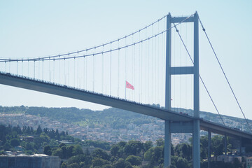 Flag displayed on a bridge in a sunny city setting in istanbul 