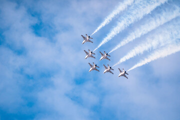 Air show planes flying in formation in blue sky