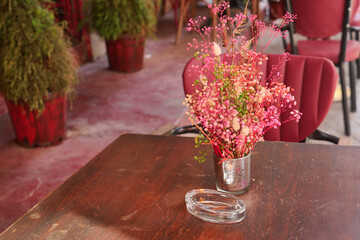 Colorful flowers in a vase at a cozy cafe table