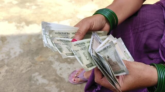 Indian female counting 500 rupees Indian currency notes	