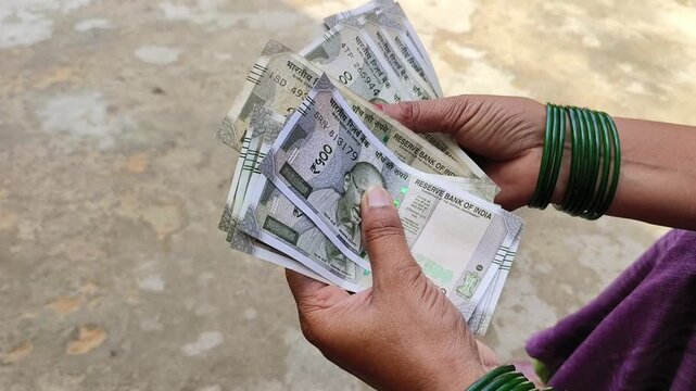 Indian female counting 500 rupees Indian currency notes	