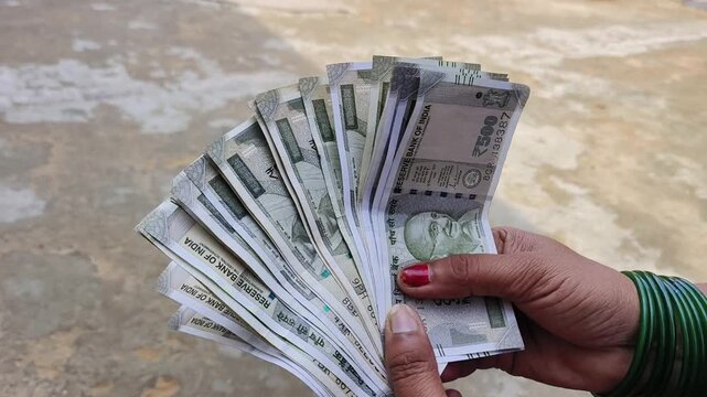 Indian female counting 500 rupees Indian currency notes	