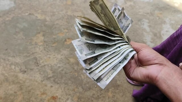 Indian female counting 500 rupees Indian currency notes	