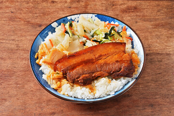 Braised pork belly rice is a beloved Taiwanese dish featuring a thick slice of soy-braised pork belly served over steamed white rice.