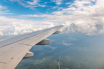 Obraz premium View from the airplane window at a beautiful cloudy sky and the airplane wing