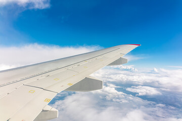 Obraz premium View from the airplane window at a beautiful cloudy sky and the airplane wing