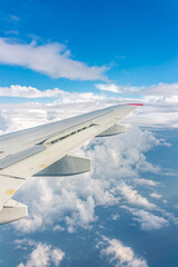View from the airplane window at a beautiful cloudy sky and the airplane wing