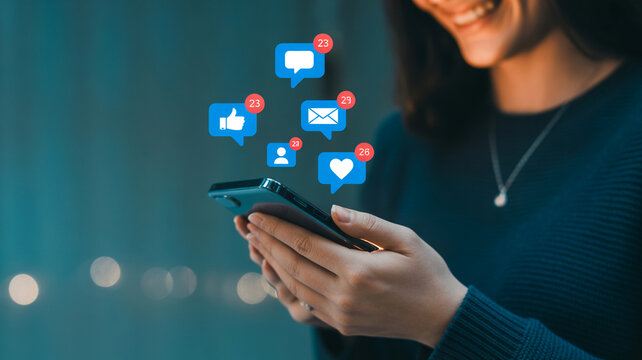 Smiling woman joyfully interacting with social media notifications on her smartphone