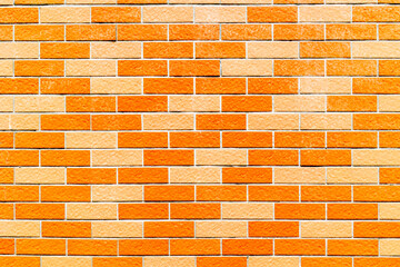Bright orange and yellow brick wall texture with uniform pattern and vivid colors