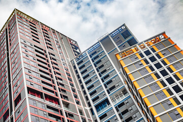 Fototapeta premium Modern urban architecture: colorful high-rise apartment buildings against cloudy sky