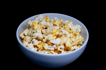 popcorns on a withe plate with black background