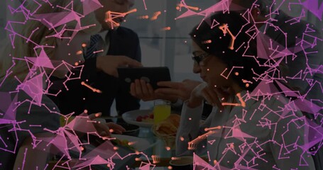 Man gesturing at tablet animating digital network, team tapping devices during business breakfast - Powered by Adobe