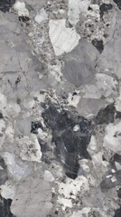Fototapeta premium Close-up of natural stone mosaic tiles with intricate texture in shades of grey, black, and white, resembling marble,