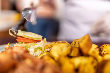 Woman preparing fried food and salad in restaurant kitchen