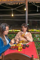 Women enjoying fried food in casual restaurant at night
