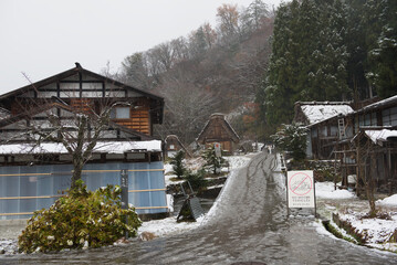 Shirakawa-go, Gifu, Japan, A sign "NO MOTORS VEHECLE" is prohibiting motor vehicles stands on a snow-covered street in front of historic Gassho-zukuri style farmhouses.