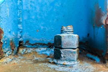screw and nut on the blue rusty plate of pole