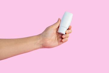 Skin care or sunscreen cosmetic and hand on pink background.