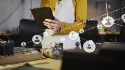 Female artisan tapping tablet in tech workshop and growing translucent network overlay mapping data - Powered by Adobe