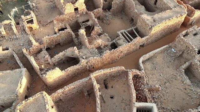 Aerial drone close-up of ancient stone houses and narrow streets in Chinguetti, Mauritania, UNESCO World Heritage desert town with historic architecture