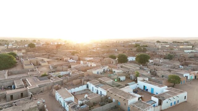 Drone flight over Chinguetti, legendary desert town of Mauritania known for ancient libraries, historic mosques and UNESCO heritage charm at golden hour