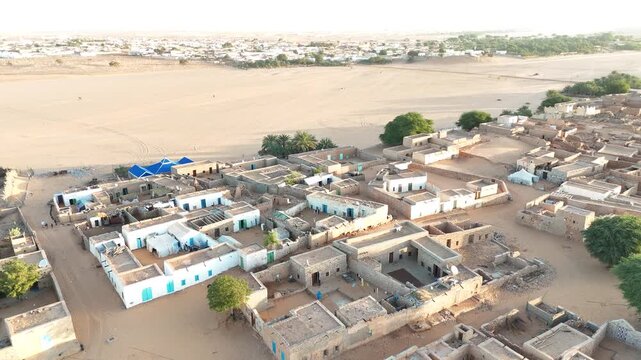 Aerial drone view of traditional houses in Chinguetti on the edge of the Sahara desert, UNESCO World Heritage site with stone architecture and desert horizon
