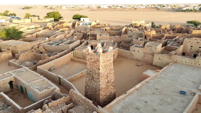 Aerial drone view of the historic mosque of Chinguetti in Mauritania, UNESCO World Heritage site with ancient stone minaret and desert town architecture