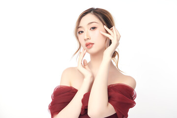 Obraz premium A beautiful young Asian woman with clean, fresh skin against a white background. Skincare, facial treatment, cosmetology, beauty, and spa. An elegant portrait of an Asian woman.