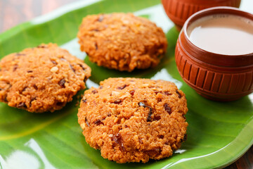 Parippu Vada or Paruppu Vadai made with toor dal. Kerala fried snacks savory food on banana leaf on dark black background. Kerala tea time food fried in coconut oil. Top view of South Indian snacks.