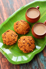 Parippu Vada or Paruppu Vadai made with toor dal. Kerala fried snacks savory food on banana leaf on dark black background. Kerala tea time food fried in coconut oil. Top view of South Indian snacks.