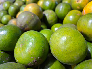 A collection of green-peeled oranges at a vendor's stall Background