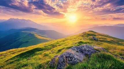 A vibrant sunset over a mountain range with a rocky outcrop in the foreground.