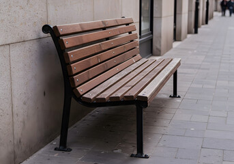 Wooden park bench beside a city street, urban setting.