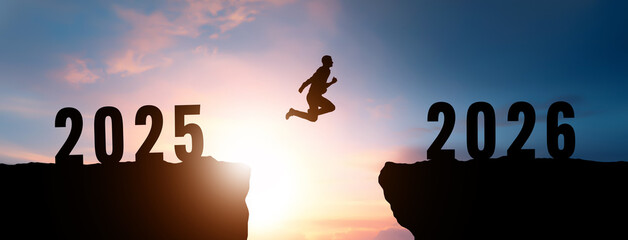 Silhouette of a man jumping between cliffs representing the jump from 2025 to 2026 with a beautiful sunrise sky