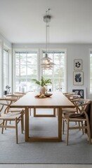 Fototapeta premium Modern Scandinavian Dining Room with Wooden Table, Wishbone Chairs, Pendant Lights, and Large software Overlooking a Winter Landscape