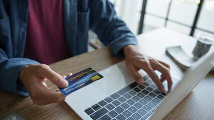 Businessman hold credit card online payment in laptop.