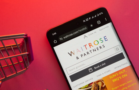 Dhaka, Bangladesh- 23 June 2025: A smartphone displaying the Waitrose & Partners website with a shopping cart is shown on a vibrant background.